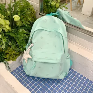 Stylish mint green backpack featuring subtle floral prints and a cute starfish pendant charm