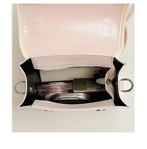 Detailed interior view of a pink mini backpack showing its storage capacity with daily items