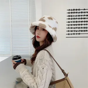 Detail view showing the soft texture of a plush cow print bucket hat on a model