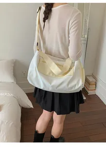 Spacious white dry and wet separation gym bag carried by a model in a cozy bedroom.