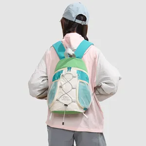 Vista trasera de una mujer con una elegante y pequeña mochila de senderismo verde y beige