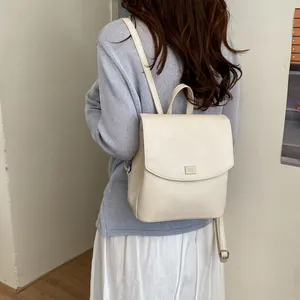 Minimalist cream faux leather backpack worn on model for lifestyle detail