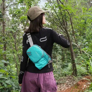 Stylish teal Korean style small crossbody bag for girls shown in an outdoor forest hiking scene