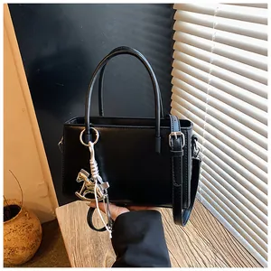 Sleek black faux leather handbag with adjustable strap and silver horse charm detail