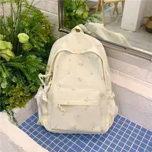 Detailed close-up of a cream floral print backpack with a cute star pendant for students