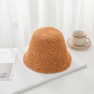 Detailed view of a warm brown lambswool bucket hat on a minimalist white table setting.