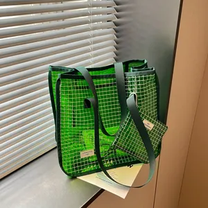 Detailed view of the green grid tote bag with matching small pouch on a window ledge.
