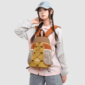 Vista detallada de una mochila de exterior de color mostaza llevada por una modelo