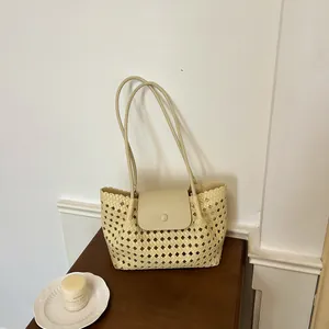 Detaillierte Nahaufnahme einer cremefarbenen gewebten Tragetasche mit schicker Klappe.
