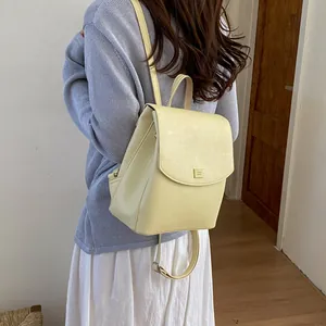 Minimalist pale yellow faux leather mini backpack for women, elegant casual commuter style