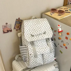 Detailed view of the stylish star-patterned backpack on a suitcase in a home setting