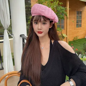 Stylish vintage pink frayed beret hat shown in a detailed outdoor close-up on a model