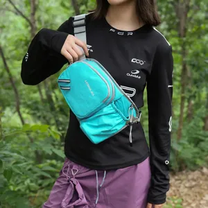 A detailed view of a stylish cyan sports crossbody bag worn by a model in nature setting
