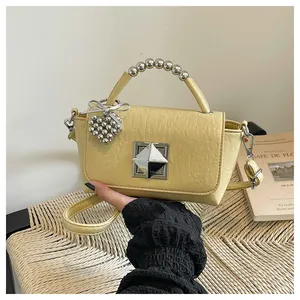 Yellow mini square crossbody handbag featuring a stylish beaded handle and silver heart charm