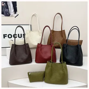 Detail view of various colored woven tote bags with matching pouches on white steps