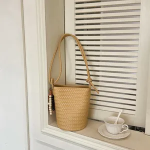 Elegante minimalistische gewebte Beuteltasche auf einem weißen Fensterbrett mit Teetasse