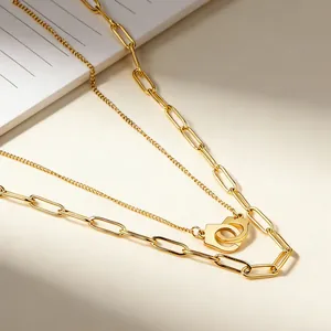 Detailed macro shot of a gold-plated double-layer necklace with handcuff pendant