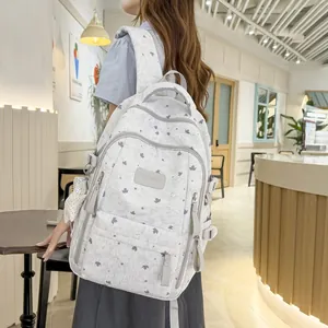Detail of a gray backpack with stars and maple leaves pattern worn by a model.