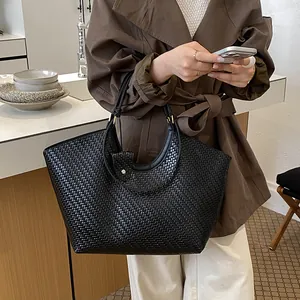 Detailed view of the large capacity black woven tote bag in a lifestyle setting