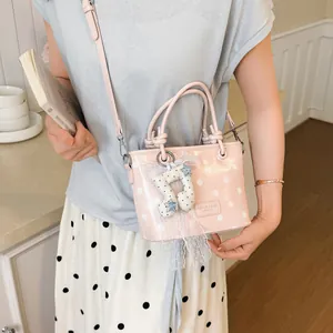 Stylish pink polka dot crossbody handbag with cute musical note charm and lace detail