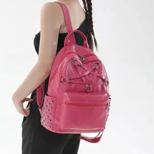 Detailansicht eines stylischen rosa Lederrucksacks mit Nieten und dekorativen Sternenriemen