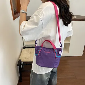 Stylish large purple and pink women's crossbody gym bag shown on model in indoor setting