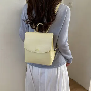 Back view of a woman wearing a minimalist light yellow fashion backpack for summer