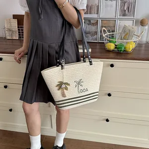 Gewebte Tragetasche mit Palmenstickerei und grünen Streifen, kombiniert mit Sommerkleid
