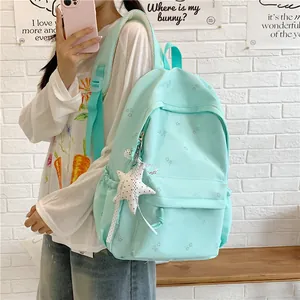 Detailed view of fresh mint green backpack with starfish pendant and floral patterns