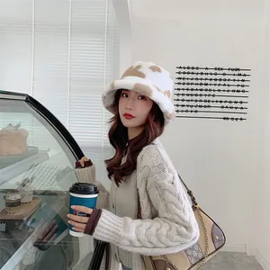 Young woman wearing a warm plush bucket hat with cow print in a cafe setting