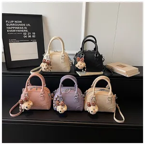 Group of small Boston handbags in five colors with cute bear pendants and top handles.