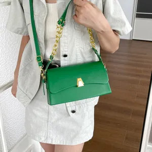 Stylish green rectangular crossbody shoulder bag with gold chain strap worn by a model