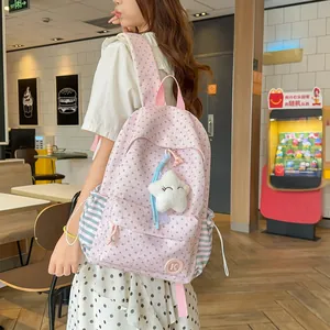 Back view of pink star pattern backpack with plush star charm worn by model in a lifestyle setting