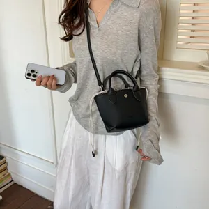 Détail d'un mini sac seau noir minimaliste avec cordon de serrage et texture grainée