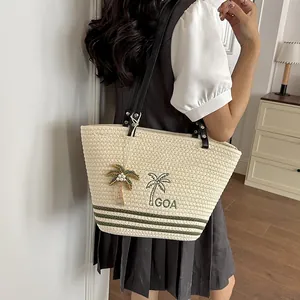 Detailansicht einer gewebten Strohtasche mit Palmenstickerei und grünem Streifenmuster.