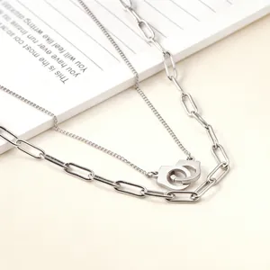 Detailed macro shot showing layered chains and handcuff pendant of this silver necklace