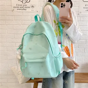 Detail view of a mint green floral student backpack in a lifestyle setting