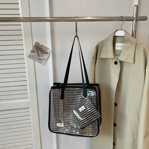 Modern transparent silver grid tote bag displayed on a rack with a stylish beige coat