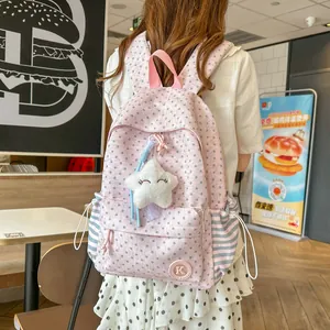 Detail view of a pink Korean style school backpack with star patterns and a plush charm.
