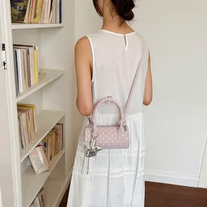 Detailed view of pink polka dot cylinder handbag with star charm accessory