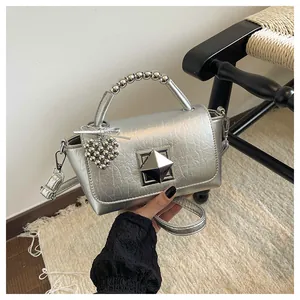 Trendy silver handbag featuring a beaded top handle and unique heart charm accessory