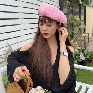 Fashionable pink distressed beret worn by model in an outdoor garden setting