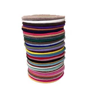 A tall stack of premium multicolored wool berets for women shown in various vibrant shades