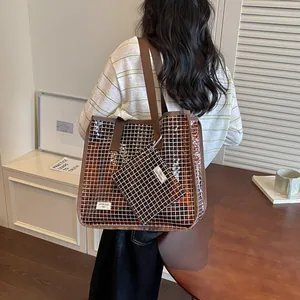 Detail shot of a brown grid pattern tote bag with a matching pouch for retro commuting.