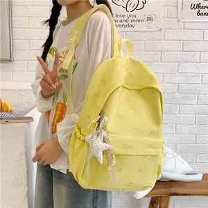 Chic yellow floral backpack with star charm shown on model for school and travel use