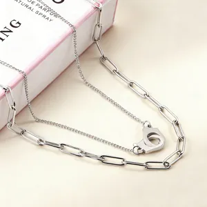 Close-up of double-layered stainless steel necklace with unique handcuff pendant design detail