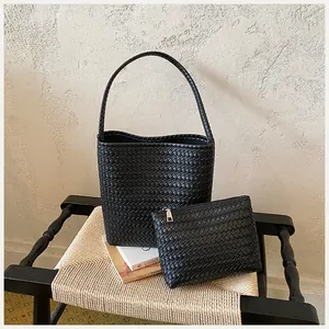 Conjunto de bolsos de cubo trenzados negros minimalistas con neceser a juego en silla