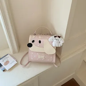 Cute pink dog-faced backpack with star pattern and plush puppy keychain in detail view