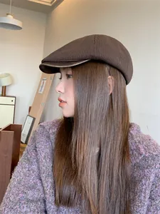 Side view of a classic brown knitted newsboy cap on an Asian female model