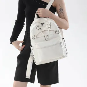 Detailansicht eines weißen Punk-Rucksacks mit Pentagramm-Riemen und Nieten.